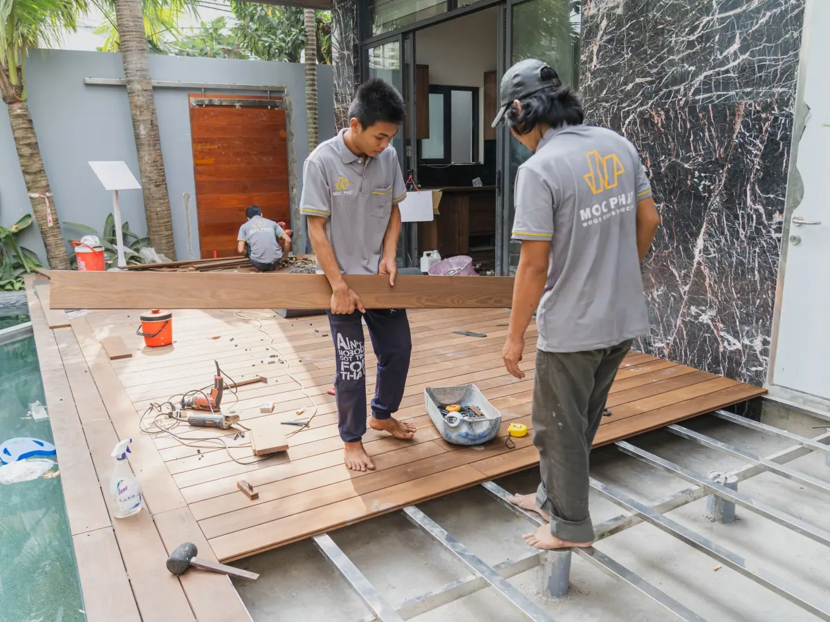 installation terrasse bois mougins Installation de terrasse en bois à Mougins : artisans posant les lames d'une terrasse en bois au bord d'une piscine